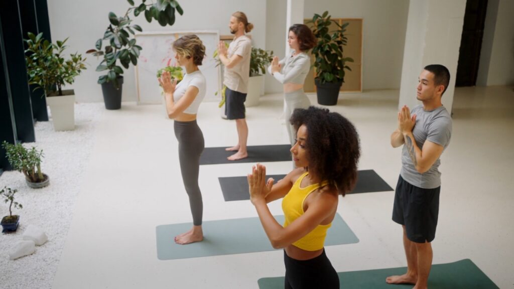 Men and women practice yoga together in a bright studio.